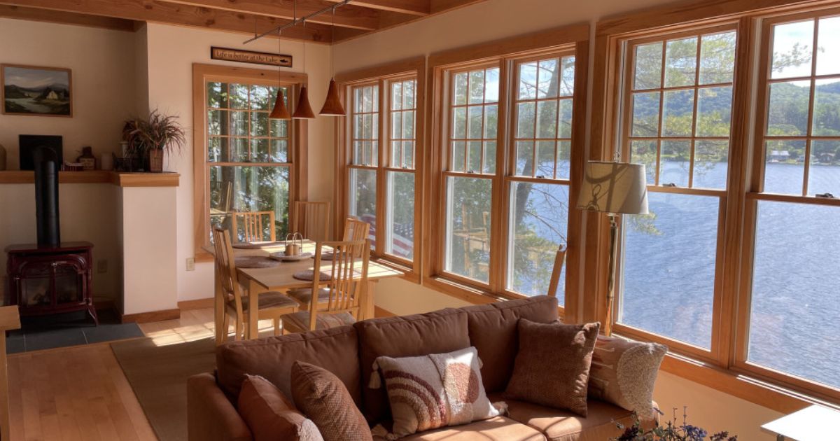 Lake cottage interior with wall of windows looking out on to lake Saint Catherine