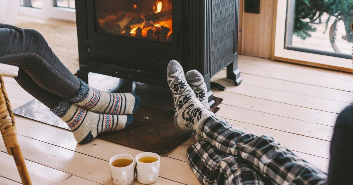 Wood stove with two individuals enjoying it